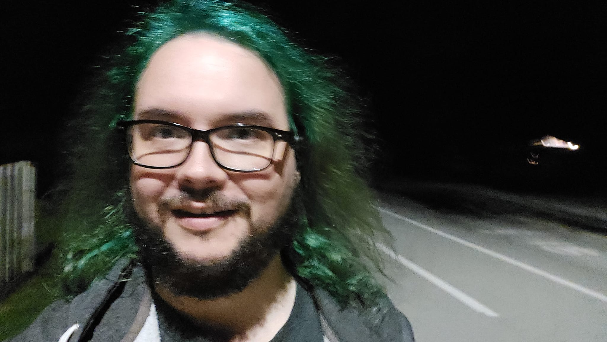 A man with green hair is outside after dark, Photo 12